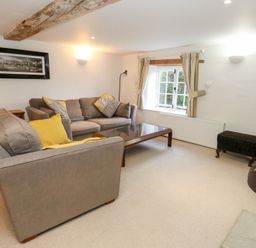A living room with a sofa and coffee table at Bubbs Cottage 