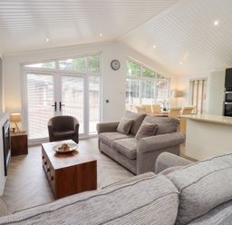 A living room with a sofa and dining area at Laughing Duck in Troutbeck Bridge