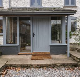 An entryway with a grey door and windows at 3 bed property