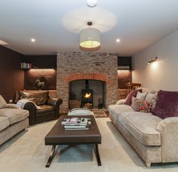 A living room with a fireplace and seating area at 3 bed property