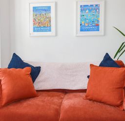 A sofa with pillows and wall art at Higher Tower Road