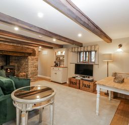 A living room with a sofa, fireplace, and television at 1 bed property in Usk