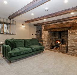 A living room with a fireplace and couch at 1 bed property in Usk