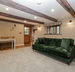 A snug with a green sofa and wooden table at 1 bed property Usk