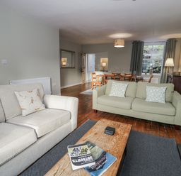 A living room with sofas and a dining area at Haulfryn Dolwyddelan