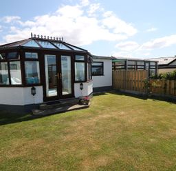 A conservatory with grass and a fence at Goetra