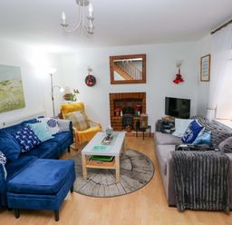 A living room with a sofa and fireplace at Tawe Cottage in Swansea