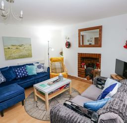A living room with sofas and a coffee table at Tawe Cottage in Swansea