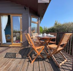 An outdoor seating area with a table and chairs at Lamorna in Sennen