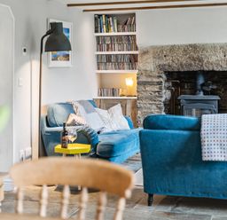 A living room with a sofa and a fireplace at Treovis Cottage in Callington