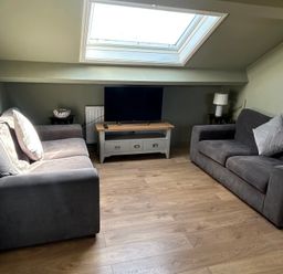 A living room with a TV and two sofas at West Cottage in East Knapton near Rillington