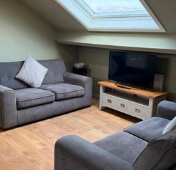 A living room with a sofa and television at West Cottage in East Knapton near Rillington