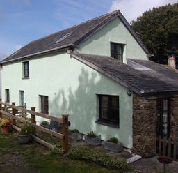 A house with a stone wall and windows at The Milking Shippon at Thorne Langtree near Great Torrington