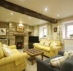 A living room with couches and a television at The Coach House in Burford