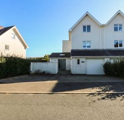 A house with a garage and hedges at 2 Lon Y Dryw in Trearddur Bay