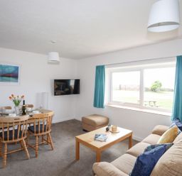A living room with a dining table and chairs at Oer - 8 Ty'n Don in Llanengan near Abersoch