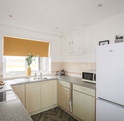 A kitchen with a refrigerator, sink, and microwave at Oer - 8 Ty'n Don, Llanengan near Abersoch
