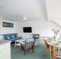 A living room with a sofa and dining table at Ysgo - 6 Ty'n Don in Abersoch