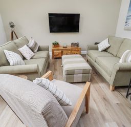 A living room with sofas and a television at Hideaway Cottage No 1 in Seahouses