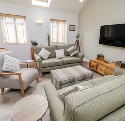 A living room with a sofa and armchairs at Hideaway Cottage No 1 Seahouses