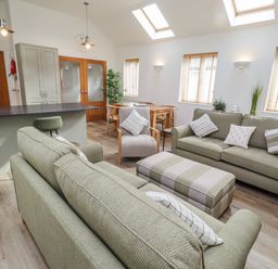 A living room with sofas and a dining table at Hideaway Cottage No 1 Seahouses