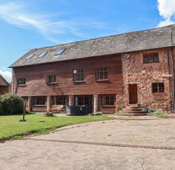 A house with multiple windows and a door at Millbarn in Crowcombe