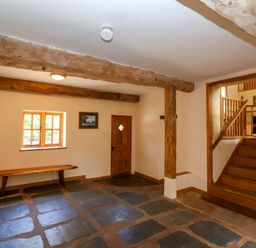 A hallway with a bench and a staircase at Millbarn in Crowcombe
