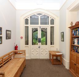 A hallway with a bench, bookshelf, and artwork at 2 Sheplegh Court in Blackawton near Dartmouth