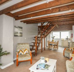 A living room with a staircase and dining area in Fadrun - 3 Ty'n Don