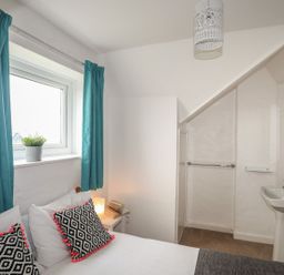 A bedroom with a bed and washbasin at Fadrun - 3 Ty'n Don