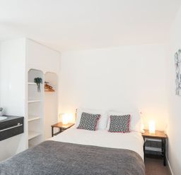 A bedroom with a bed, sink, and shelves at Towyn - 7 Ty'n Don