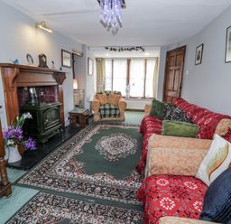 A living room with a fireplace and seating arrangements at The Old Post Office in null