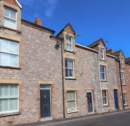 Row of houses with stone facades on a street at Lenny's Place in Watchet