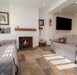 A living room with a fireplace and two sofas at Lenny's Place in Watchet