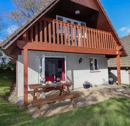 An outdoor area with a table and chairs at Mayfly Lodge in St Tudy