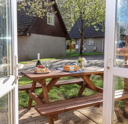 An outdoor dining area with a table set for lunch at Mayfly Lodge, St Tudy