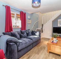 A living room with a sofa and coffee table at Mayfly Lodge in St Tudy