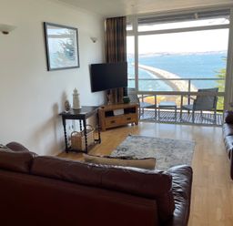 A living room with a television and seating area at Snowy Owl View at The Breakwater Brixham