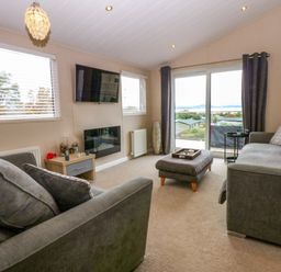 A living room with a sofa and television at The Hideaway in Pwllheli