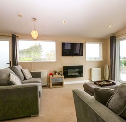 A living room with a sofa and television at The Hideaway in Pwllheli