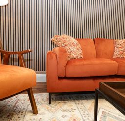 A living room with orange sofa and armchair at The Studio in Windermere