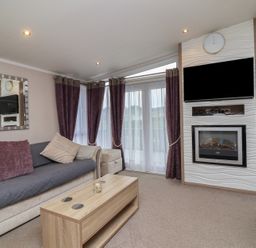 A living room with a sofa and a television at Whistler in Wimborne