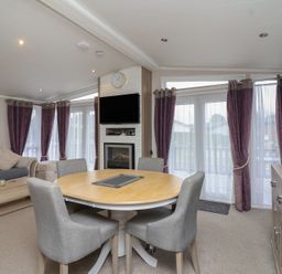 A living room with a sofa and dining table at Whistler in Wimborne