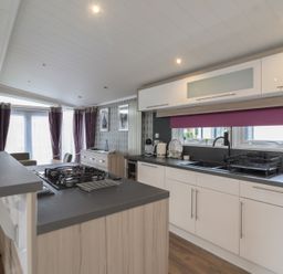A kitchen with a gas stove and sink at Whistler in Wimborne