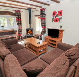A living room with a sofa and television at Carthouse Cottage in Clarbeston Road