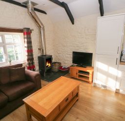 A living room with a coffee table and sofa at Knap Cottage in Clarbeston Road