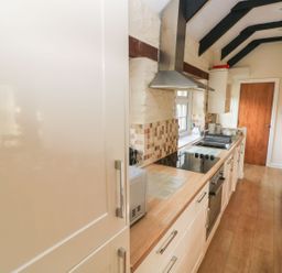A kitchen with cabinets and a stove at Knap Cottage in Clarbeston Road