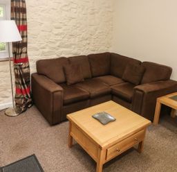 A living room with a sofa and table at Corner Cottage in Clarbeston Road