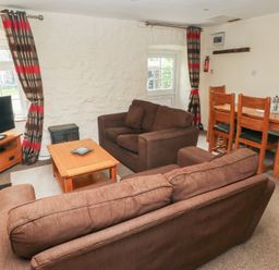 A living room with a sofa and dining table at Stable Cottage in Clarbeston Road