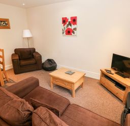 A living room with a sofa and coffee table at Swallows Cottage in Clarbeston Road